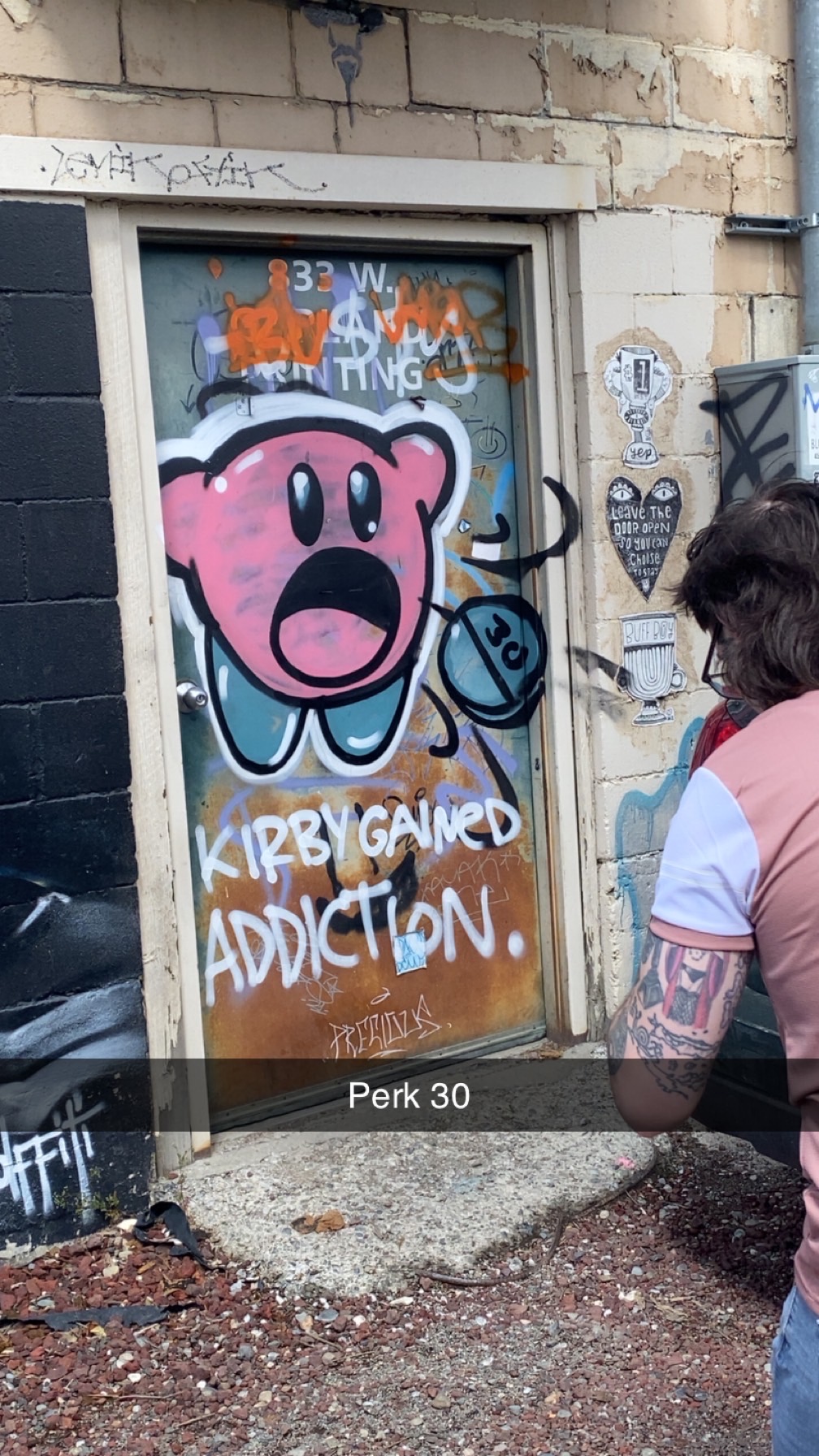 Pink Kirby character graffiti painted on a door